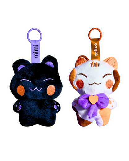 Two plush keychains, one black and one orange with a white face, on a white background.
